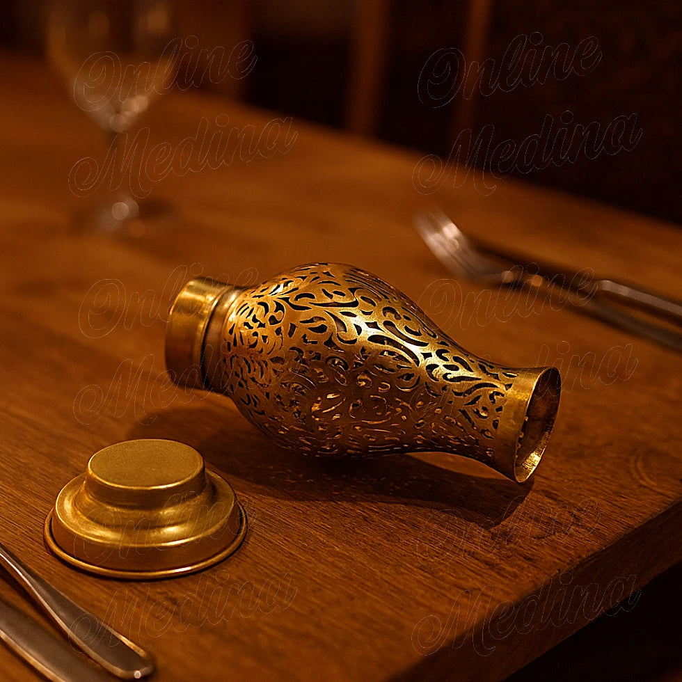 Open brass candle holder on an elegant wooden dining table with cutlery
