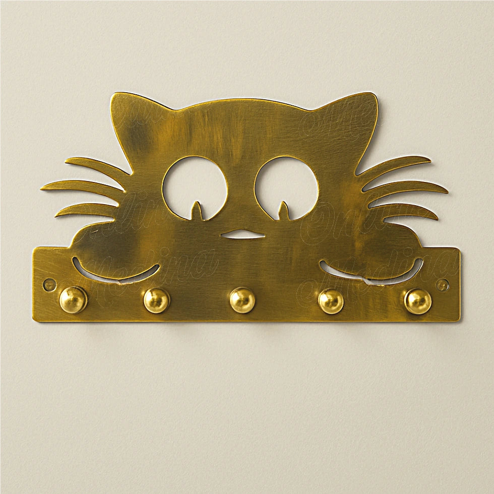 Brass cat-shaped wall key holder on light wall with round brass hooks
