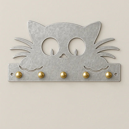 Silver alloy cat-shaped wall key holder with brass hooks on neutral wall