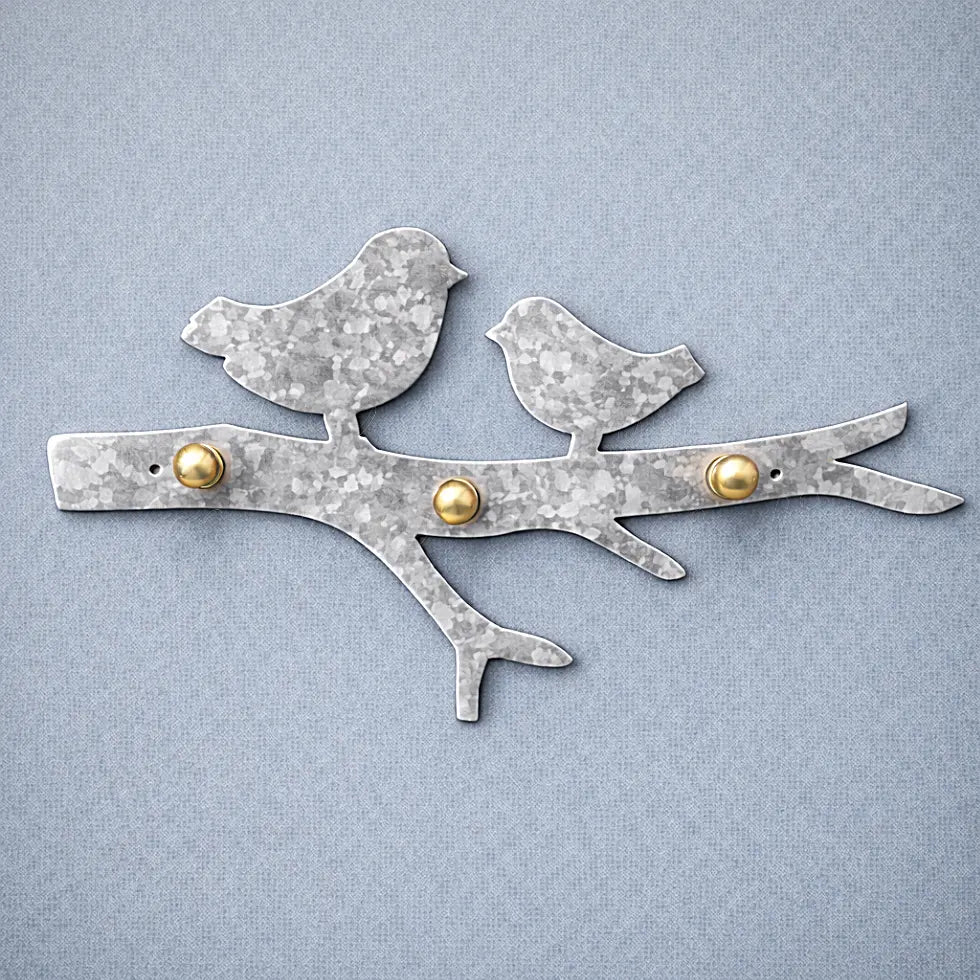 Hammered galvanized metal bird wall key holder with visible artisan texture and solid brass hooks