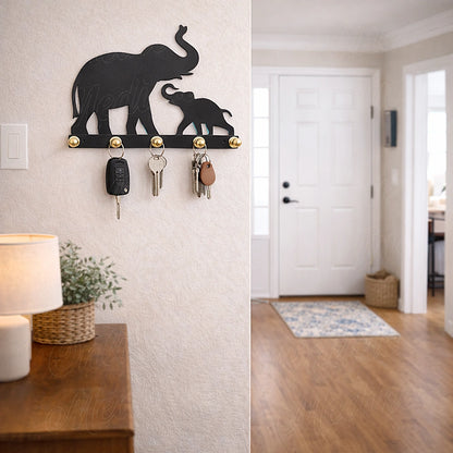 Elephant mother and baby wall key holder in black metal, shown in a modern entryway with keys hanging