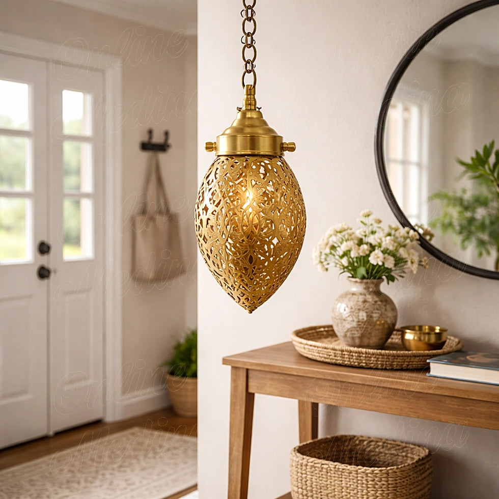 Glowing openwork brass ovoid pendant beside a wooden console and round mirror in an entryway