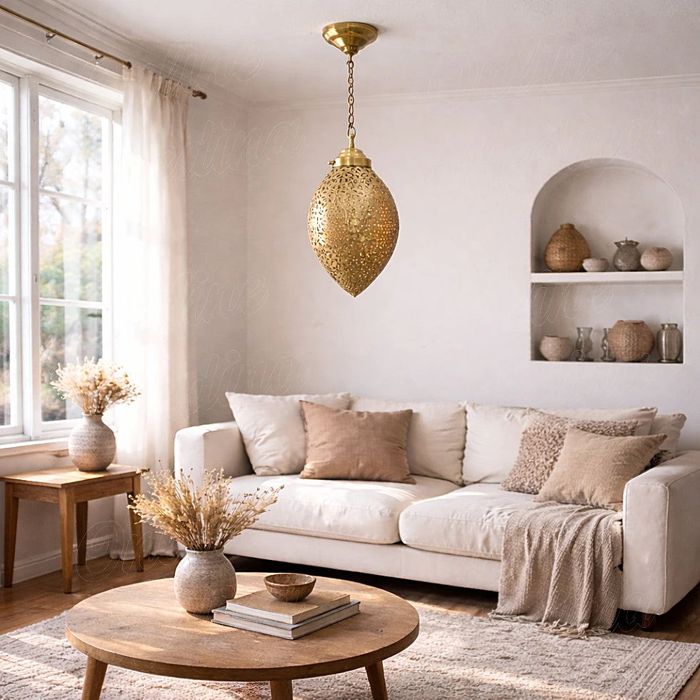 Openwork brass ovoid pendant in a bright living room with a white sofa and round coffee table
