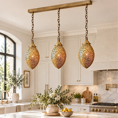 Three glowing brass ovoid pendants on a rectangular canopy in a kitchen with an arched window