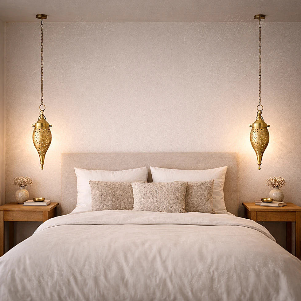 Handmade Moroccan brass teardrop pendant lights hanging above a bed in a calm minimalist bedroom setting