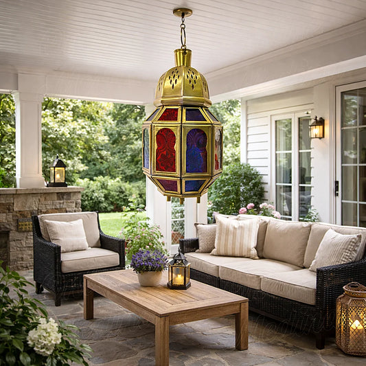 Traditional Moroccan brass candle lantern with colored glass panels displayed in covered patio setting
