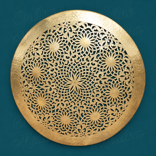 Round golden brass wall sconce with openwork floral rosettes and a wide hammered rim against a deep teal background.