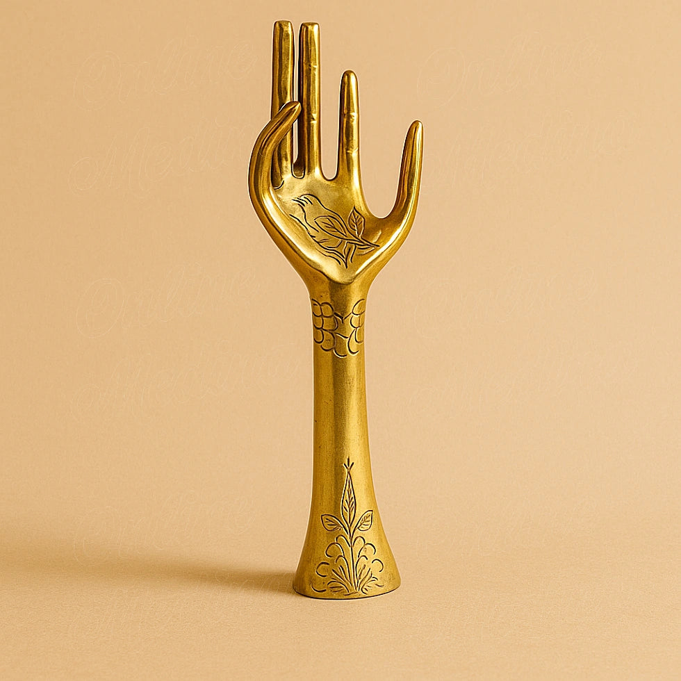 Handcrafted brass hand sculpture engraved with Moroccan floral motifs, displayed on a plain beige background