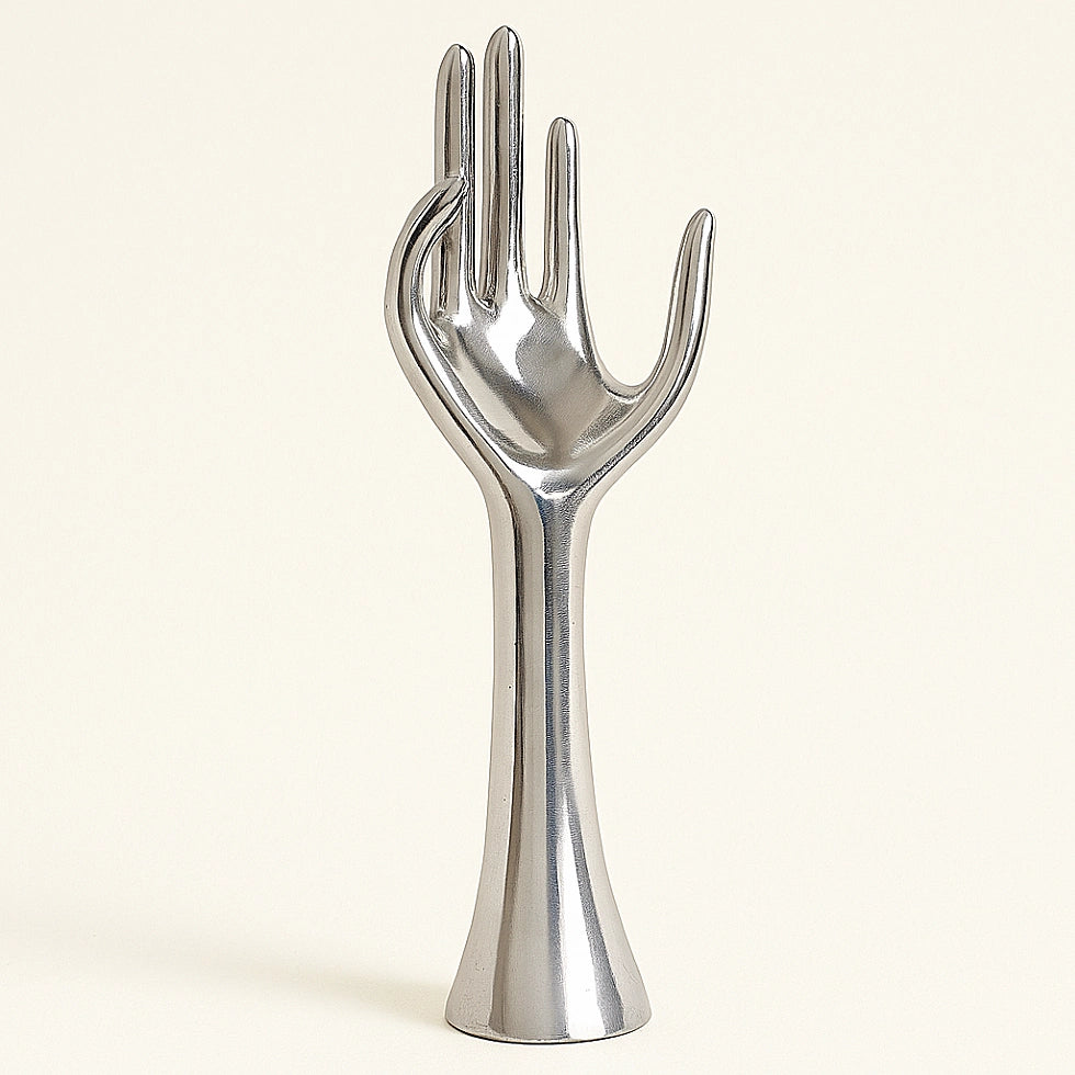 Polished aluminum hand sculpture with smooth surface and minimalist design, on a light neutral background