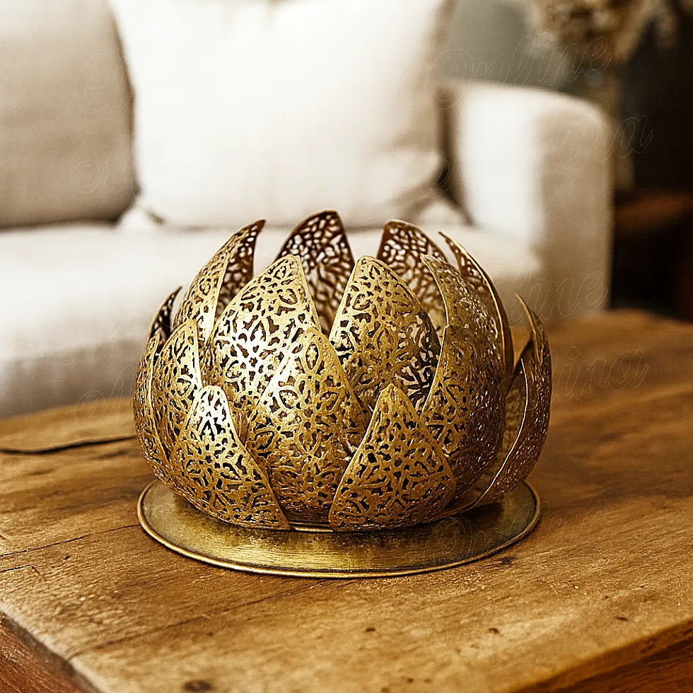 Dans un salon aux tons naturels, une lampe en laiton doré aux pétales de lotus repose sur une table rustique en bois