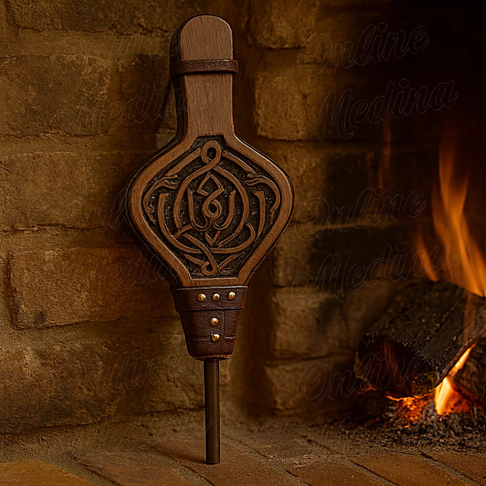 Decorative Moroccan fireplace bellows in dark carved wood, leaning against a brick fireplace with warm fire.