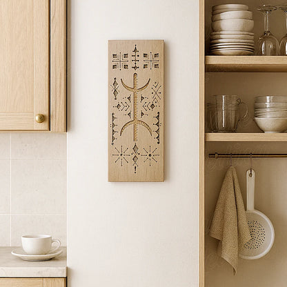 Hand-carved Berber cedar wood wall amulet displayed in a modern European kitchen, showcasing Moroccan craftsmanship and Amazigh symbols.