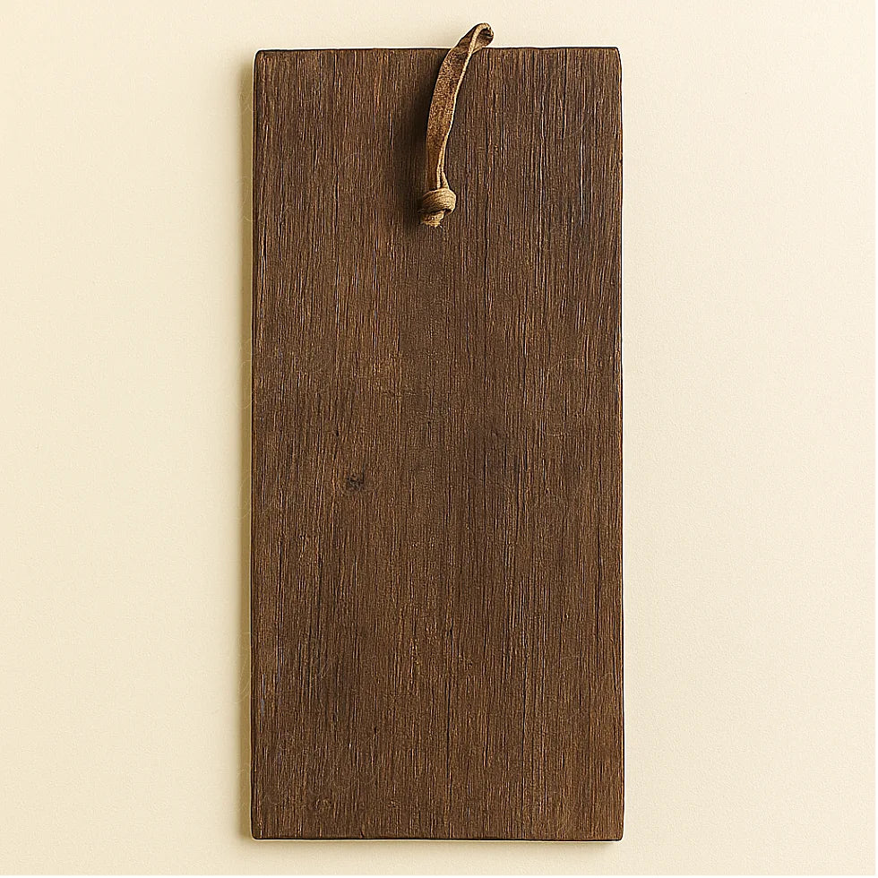 Back view of a handmade Berber wooden amulet showing the smooth dark brown cedar surface and the leather hanging loop.