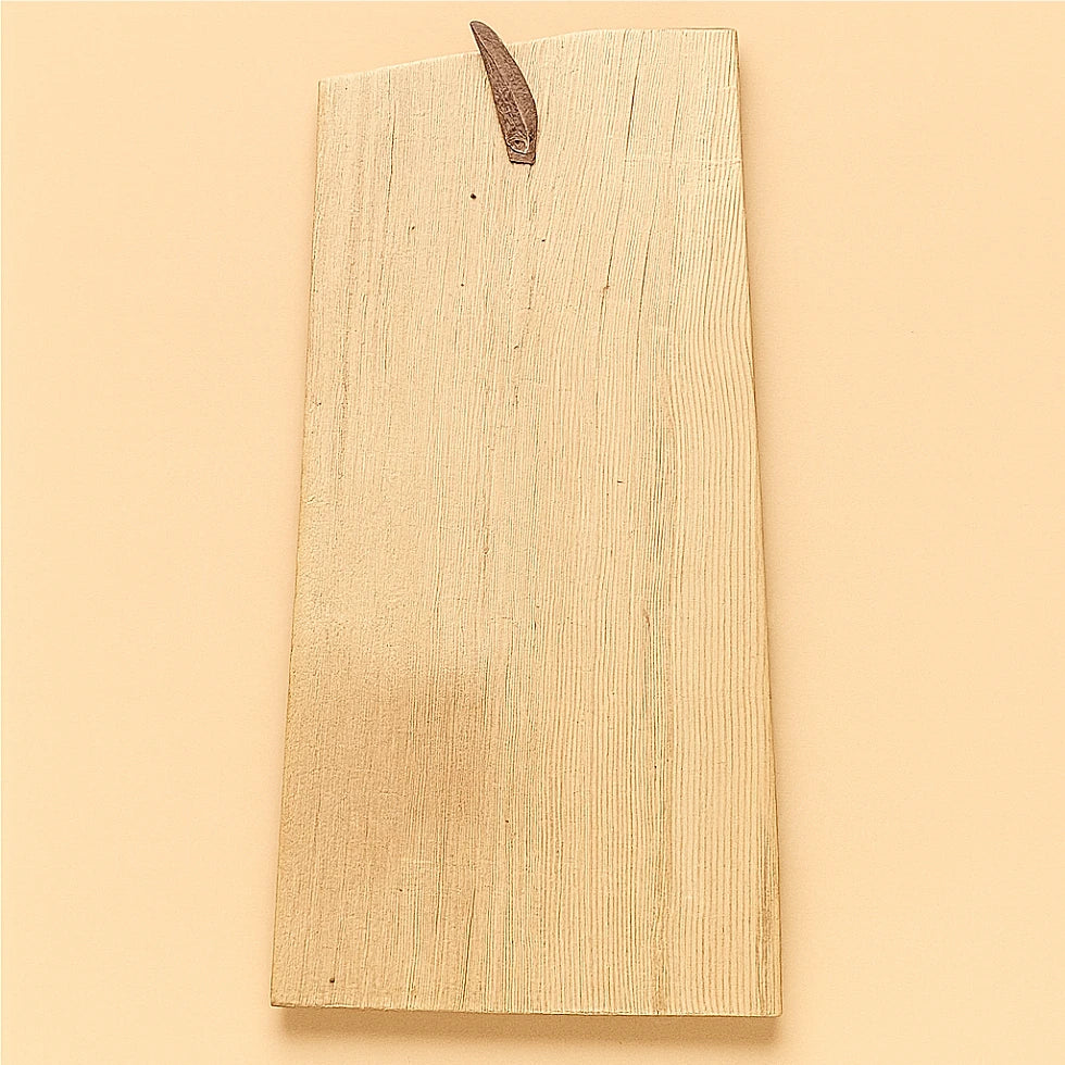 Back view of the same handcrafted Moroccan cedar wood wall amulet showing the natural wood grain and leather hanging strap on a beige background.