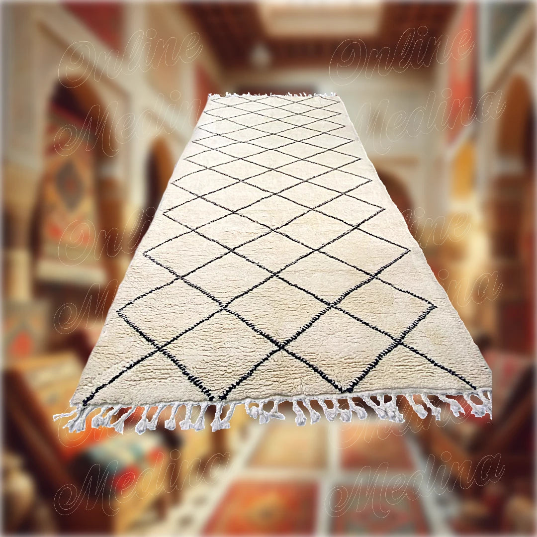 Tapis Beni Ouarain artisanal marocain en laine blanche avec motifs noirs en losanges, posé dans une boutique traditionnelle de tapis marocains.