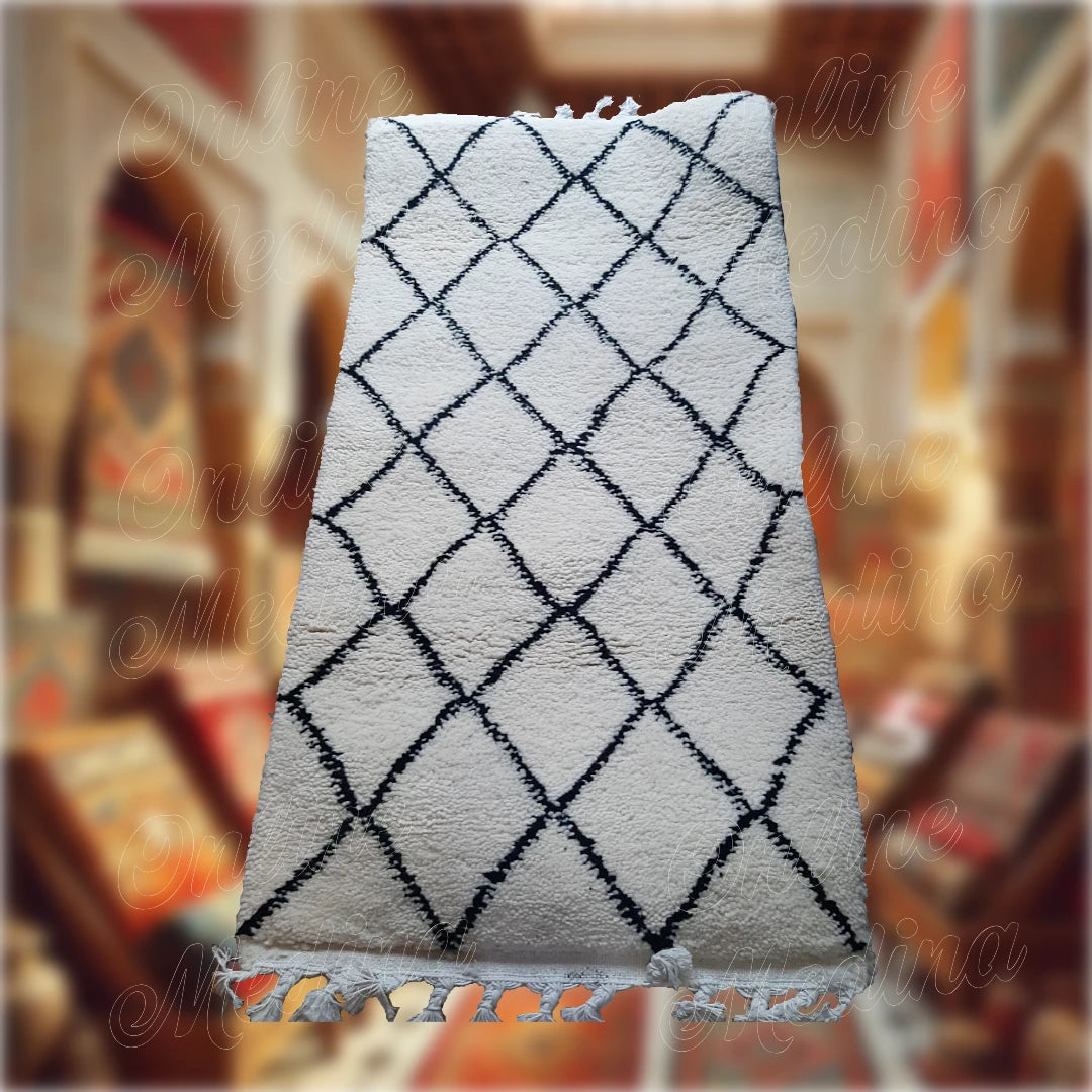 Tapis Beni Ouarain artisanal marocain en laine blanche avec des motifs losanges noirs, tissé à la main, idéal pour une décoration intérieure chaleureuse et authentique.