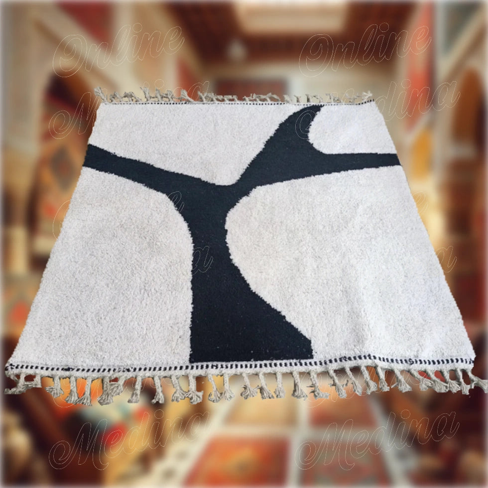 Modern Middle Atlas rug in white wool with subtle black motifs, handcrafted in Morocco for an elegant and minimalist living space.