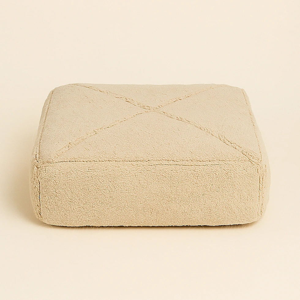Square Moroccan pouf in handwoven beige wool, crafted in Rabat by master artisan Omtad, minimalist design on a plain background for e-commerce presentation.