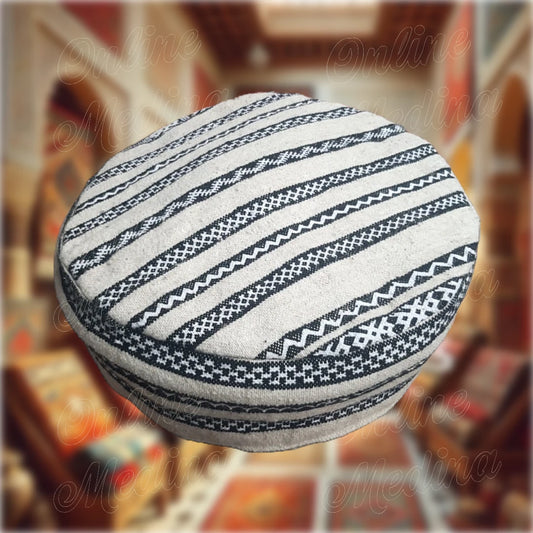 Handmade Berber pouf in beige natural wool, offering a clean and minimalist design for refined home décor.