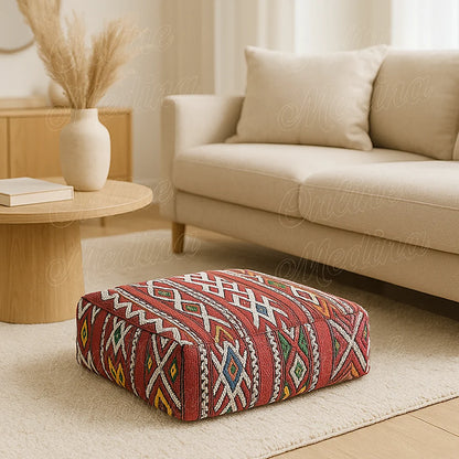 Moroccan square pouf with multicolored Berber patterns in a bright living room