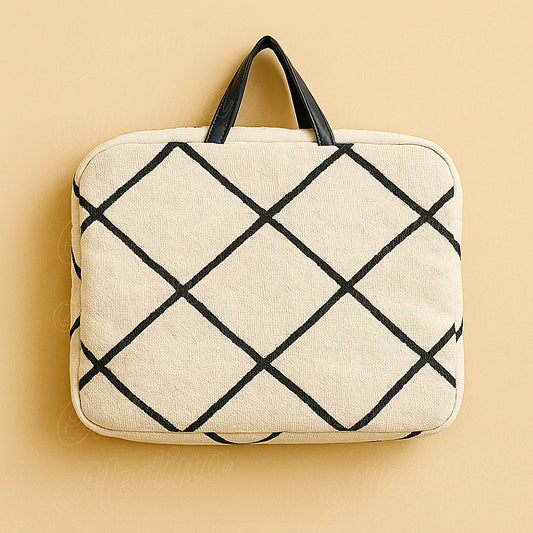 Moroccan Beni Ouarain laptop sleeve on beige background, handcrafted wool and black geometric patterns