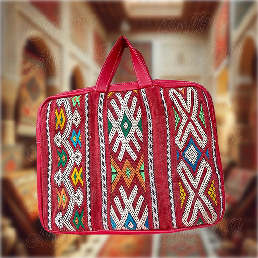 Vue arrière d’une sacoche artisanale en tapis Hanbel rouge, motifs berbères marocains distincts, avec poignées en cuir noir.