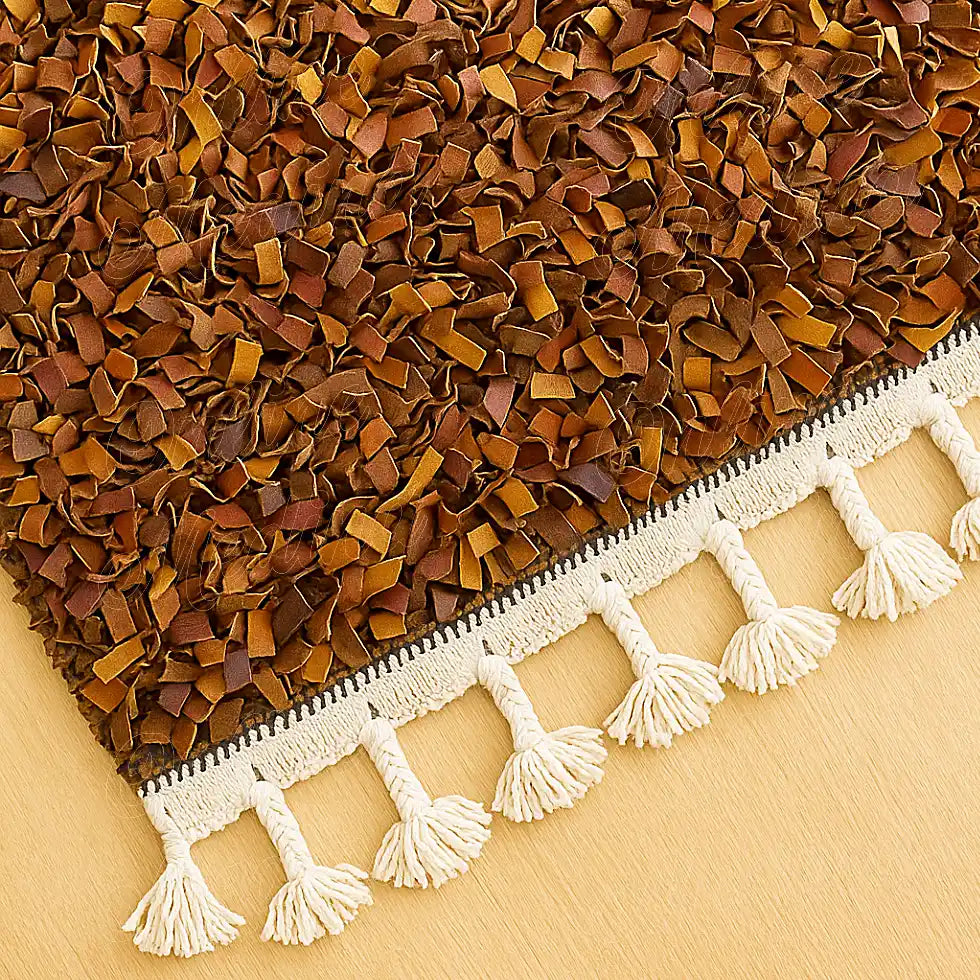 Close-up of a Moroccan boucharouite rug showing detailed handwoven texture and soft brown leather strips with white fringes.