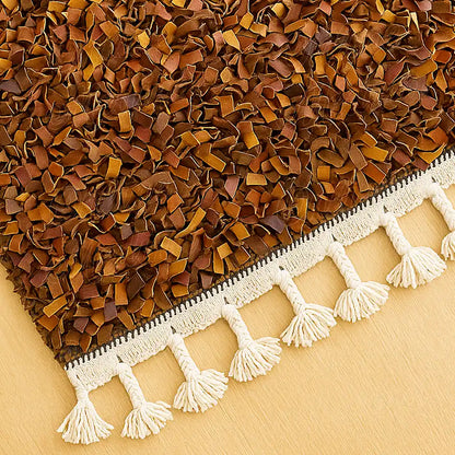 Close-up of a Moroccan boucharouite rug showing detailed handwoven texture and soft brown leather strips with white fringes.