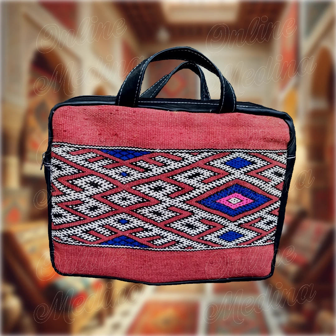 Sacoche pour ordinateur portable en tissu Hanbel rouge, ornée de motifs berbères traditionnels et équipée d'anses en cuir noir véritable, alliant artisanat marocain authentique et design moderne.