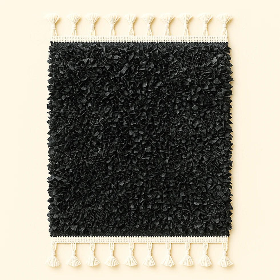 Black Moroccan boucharouite rug crafted from soft recycled leather strips with white fringes, photographed on a plain beige background.