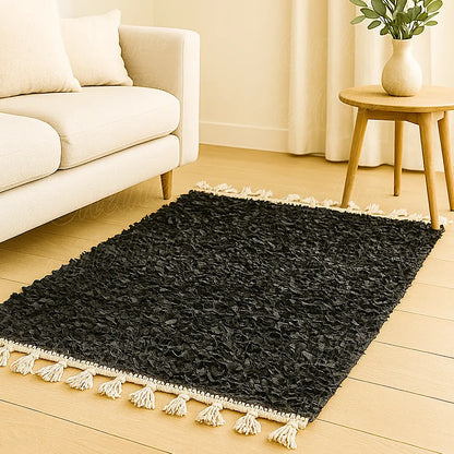 Black boucharouite rug made from handwoven leather strips displayed in a modern European living room with warm tones and minimalist decor.