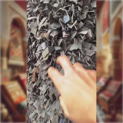 Video showing a hand passing through the soft leather strips of a Moroccan Boucharouite rug — highlighting texture and artisan quality.